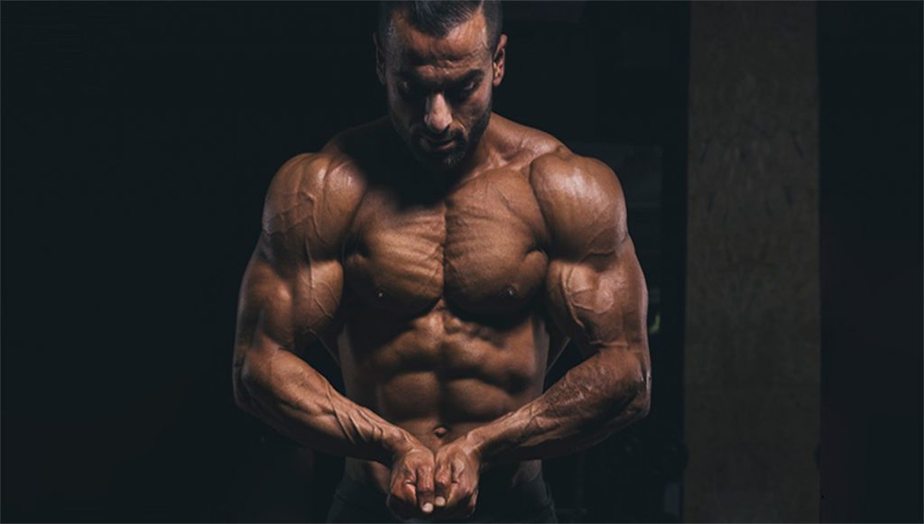 Homem com músculos definidos mostrando como ganhar massa muscular.